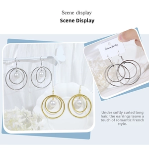 Detail of geometric stainless steel hoop earrings with pearls in gold and silver