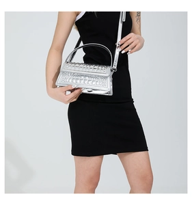 Detail of silver crocodile pattern glossy handbag with adjustable shoulder strap and flap
