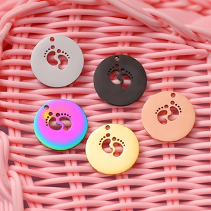 Five round metal pendant charms with hollow baby footprint designs in multiple colors