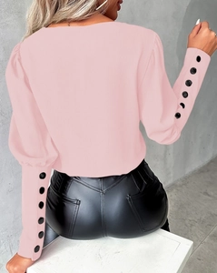 Detail of pink long sleeve shirt showing buttoned cuffs and modern slim fit silhouette