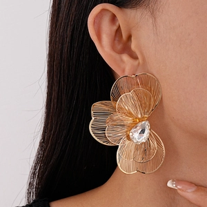Detail of gold petal earrings with multi-layered wire mesh and crystal center