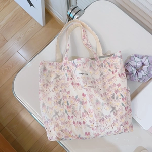Floral canvas handbag with pink rabbits and simple wish label on a white tabletop