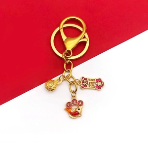 Golden lion dance fish keychain with lucky charms on red and white background
