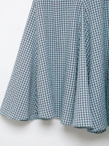 Detailed macro view of the sky blue gingham seersucker fabric texture and wavy hemline