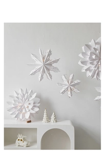 Close-up of white paper star and snowflake pendants hanging in a festive scene