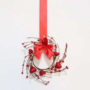 Red heart berry candle ring with twigs and ribbon bow for Valentine Day table decoration