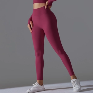 Detail of high waisted yoga set in dark rose featuring thumb holes and ribbed texture