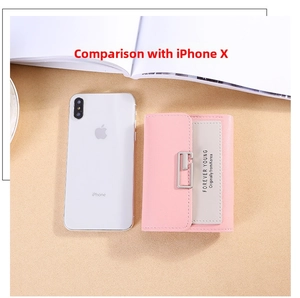 Size comparison of the tri-fold pink and grey wallet with a smartphone for scale
