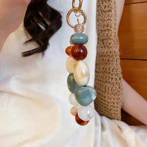 Detail of colorful acrylic beaded keychain with gold metal ring on a casual outfit