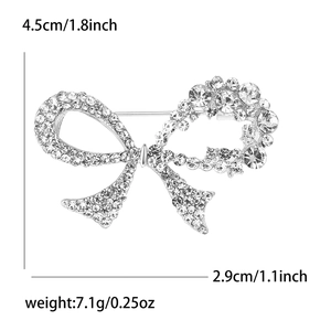 Elegant silver bow brooch with rhinestones, 4.5cm length, 7.1g weight on white background