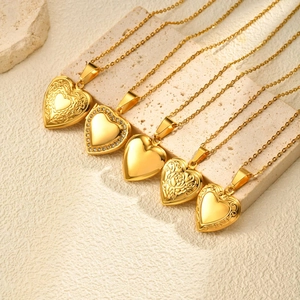Five gold heart locket necklaces with floral engraving and crystal accents on stone