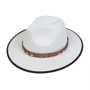 Detailed close-up of white felt cowboy hat featuring brown leather band and metal rivets