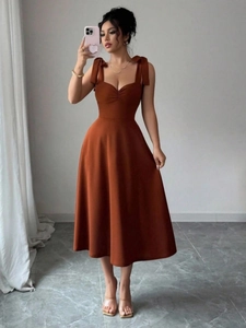 Elegante bruine midi-jurk met schouderstrikjes en een slanke gebreide pasvorm