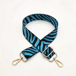 Detail of blue zebra pattern woven bag strap with adjustable gold-tone metal buckles