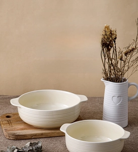 Detailed view of cream ceramic soup bowl with side handles and ribbed texture design