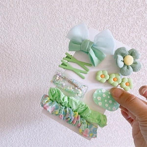 Detail of floral green fabric bow clips and scrunchies hair accessory set for girls