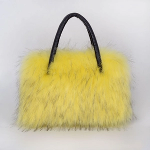 Detail of fluffy yellow faux fur texture on a high-end tote bag with a black leather handle