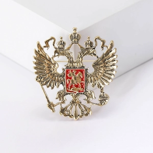 Vintage gold double-headed eagle brooch with red shield emblem on white steps