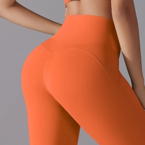 Detail view of high-waist orange yoga pants showing push-up seam and body shaping effect