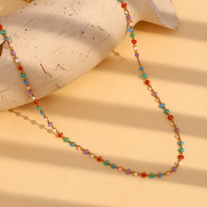 18K gold plated stainless steel necklace with colorful enamel beads on textured prop