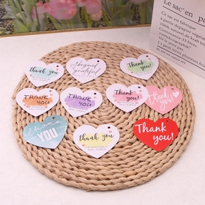 Macro shot of colorful heart-shaped paper thank you gift tags for small business packaging