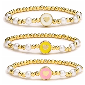 Trois bracelets en perles avec billes dorées, perles et breloques en cœur émaillé coloré