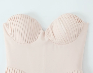 Detail of light pink strapless dress bodice featuring intricate pleated chest cup design
