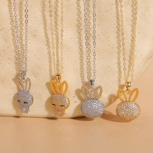 Chic rabbit zircon necklaces in gold and silver finish on elegant stone background