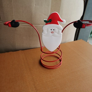 Close-up of Santa Claus metal wine bottle holder with red spiral base and white head