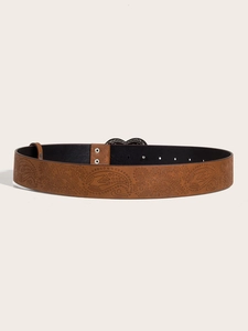 Detail of brown leather belt featuring vintage embossed paisley floral patterns and silver buckle