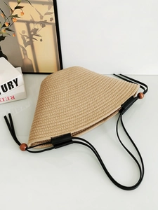 Minimalist beige woven tote bag with black slim handles and decorative wooden beads