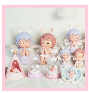Macro view of cute pink resin angel figurines with rabbit ears and crystal balls