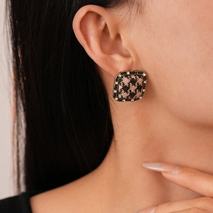 Detail view of retro square houndstooth earrings with sparkling rhinestones and gold trim