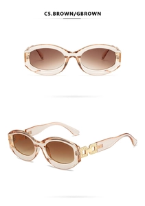 Detail view of oval sunglasses with translucent brown frames and gold chain temples