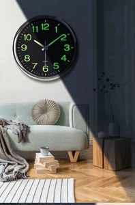 Day and night comparison of 12-inch wall clock showing luminous glow-in-the-dark numbers