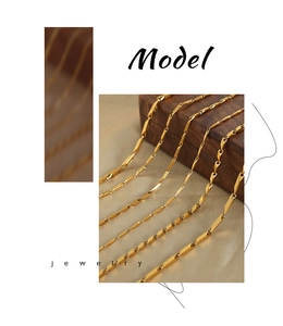 Detail of diverse gold plated titanium steel necklace textures on velvet and wood base