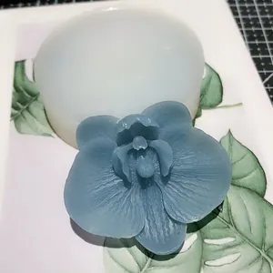 Round silicone orchid mold with blue resin flower showing detailed petal texture