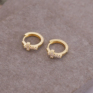 Detailed view of gold plated cross huggie earrings with micro-set cubic zirconia stones