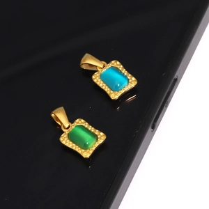 Detailed macro view of hammered gold rectangle pendants with blue and green cabochon stones