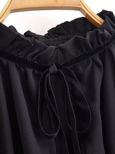 Detail of ruffled neckline with black velvet ribbon tie on elegant French blouse