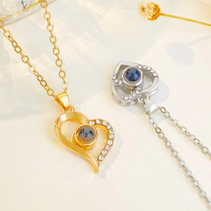 Heart projection necklace in gold and silver with zircon accents and 100 languages pendant