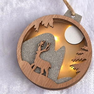 Lighted wooden Christmas ornament with reindeer cutout and warm LED lights on white faux fur