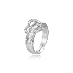 Close-up of silver heart ring with sparkling cubic zirconia on a white reflection surface