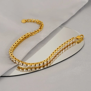 Bracelet tennis en acier doré avec zircons brillants posé sur un miroir ovale