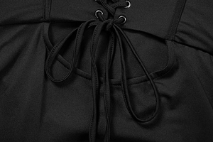 Close-up of black strapless dress featuring lace-up metal eyelets and hollow cut-outs
