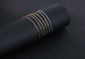 Macro detail of S925 sterling silver tassel threader earrings in gold, silver and rose gold