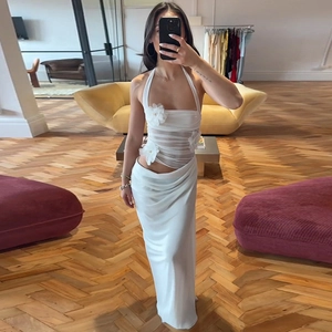 Détail des fleurs 3D et du tulle plissé sur une robe blanche à licou sophistiquée