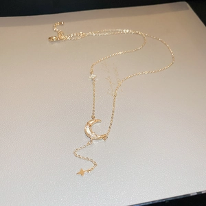 Vue macro du collier lune et étoile doré 18 carats avec nacre blanche et cristaux de zircon