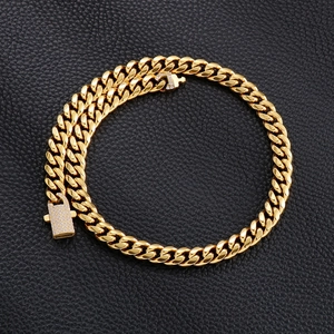 Detailed top view of gold Cuban link chain with diamond clasp on black leather