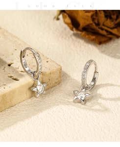 Detailed view of S925 sterling silver star earrings with moissanite on a stone surface